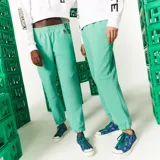 Pantalón de jogging verde agua con cintura elástica y puños ajustados. Presenta un logo de Lacoste y Minecraft en el muslo.