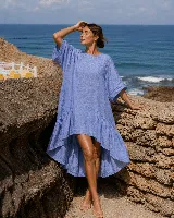 Vestido corto de lino color blanco, con mangas cortas amplias, escote redondo y diseño asimétrico más corto en la parte delantera y con volados en el ruedo.