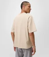 Remera boxy de algodón color beige, de cuello redondo, manga corta y corte amplio. Cuenta con un pequeño bordado con la inscripción "think slowly" en el centro del pecho.