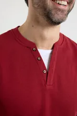 Remera de manga larga en tejido elastizado, color azul, con cuello tipo camisa, cartera con botones y detalles en eco gamuza en la base del cuello y la cartera.