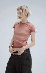 Remera de manga corta, cuello redondo, confeccionada en tejido ribb 100% algodón. Diseño ajustado al cuerpo con largo a la cadera. Presenta un tono rosado desgastado y costuras expuestas en hombros y laterales.