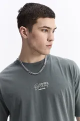 Remera de manga corta color gris oscuro, con escote redondo y estampado frontal con la frase "Immortal Dreams" en blanco.