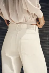 Jeans Z1975 wide leg de tiro alto color crudo, con bolsillos delanteros, bolsillos de parche en la espalda, costuras laterales destacadas y cierre frontal con cremallera y botón.