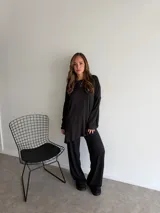 Pantalón de lanilla color negro, de corte recto y tiro alto, con diseño holgado y fluido.