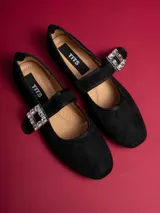 Chatitas negras de gamuza con correa sobre el empeine y hebilla con strass.