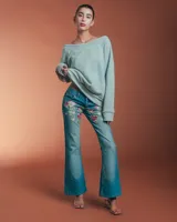 Buzo gris de friza de algodón con bordado rosa en el frente, de corte holgado y mangas largas.