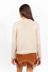 Sweater de punto color marfil, con cuello redondo, mangas largas y calce holgado. Presenta un bordado artesanal en el frente con diseño de dos músicos y un pez sobre fondo celeste.