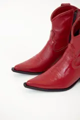 Bota de caña media baja realizada en cuero engrasado color negro, con detalle de punta fina y taco de 5 cm. El interior está forrado en forrería vacuna y el fondo es de madera.