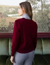 Cardigan rojo tejido en hilado fino, con escote en V y abertura central con botones metálicos.