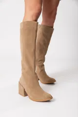 Bota bucanera de caña alta color visón, confeccionada en cuero descarne, con cierre lateral y taco cuadrado forrado.