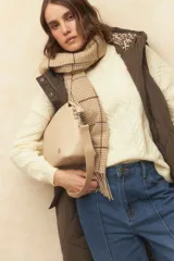 Bufanda a cuadrillé en tonos beige con flecos en los extremos.