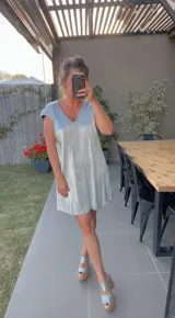 Vestido corto plateado con escote en V y mangas cortas.