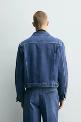 Cazadora de denim de algodón con corte relajado, cuello solapa, cierre frontal de botones y mangas largas con puños abotonados. Presenta bolsillos de solapa en el pecho y bolsillos laterales de vivo, con un acabado de efecto lavado.