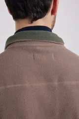 Chaleco marrón de polar con cierre frontal y cuello alto.