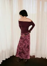 Falda larga de corte evasé confeccionada en tejido jacquard con estampado floral en tonos rosados y bordó. Presenta cintura elástica y forro interior.