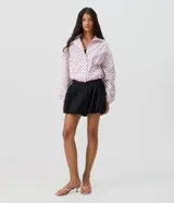 Minifalda negra de jacquard con tiro alto, cintura estructurada y corte baloné voluminoso.