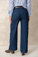 Pantalón de jean azul de corte ancho y tiro alto, con diseño de cinco bolsillos y costuras a la vista.