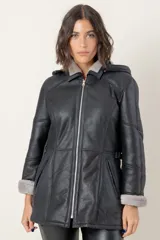 Campera de babylamb color negro con interior de piel sintética gris. Presenta cierre frontal, capucha desmontable, bolsillos laterales y presillas ajustables en la cintura.