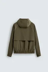 Cazadora relaxed fit color negro, confeccionada en tejido técnico ligero que repele el agua. Cuenta con cuello subido, capucha ajustable, manga larga y cierre frontal con cremallera. El interior está forrado con tejido de estructura abierta y tiene bolsillos frontales ocultos en la costura. Los acabados son elásticos.