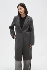 Tapado de corte recto y largo midi, confeccionado en paño gris. Presenta solapas clásicas, cierre frontal con un botón y bolsillos laterales.