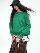 Sweater de tejido de punto en color rosa claro con motas de colores, de corte holgado, cuello redondo y mangas largas con hombros caídos.