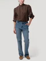 Pantalón de jean tiro alto y pierna recta, confeccionado en denim azul. Presenta diseño clásico estilo carpintero con trabilla lateral para herramientas y bolsillos diagonales.