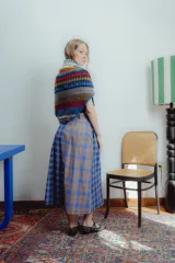 Bufanda triangular tejida a mano en lana y algodón, con diseño multicolor y botón frontal.