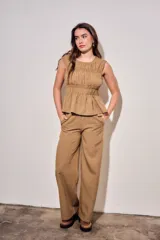 Pantalón de corte ancho con estampado a cuadros vichy en tonos marrón y tostado, cintura elástica y diseño fluido.