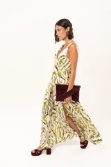 Vestido largo de tela sedosa con estampado abstracto en tonos verde oliva, blanco y negro. Presenta escote en V profundo, tirantes anchos y tajos laterales pronunciados en la falda.