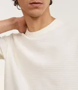 Remera de manga corta con cuello redondo, confeccionada en tejido texturizado de mezcla de algodón y poliéster en color blanco.