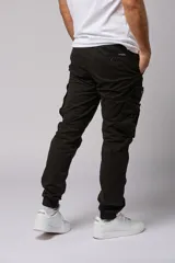 Pantalón cargo color beige de gabardina, con corte ajustado, bolsillos laterales con fuelle y puños elásticos en los tobillos.