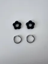 Aros de acero quirúrgico argolla con dije colgante en forma de flor de resina color gris marmoleado.
