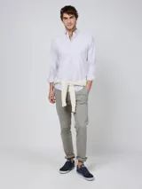Camisa Oxford de corte regular fit, color blanco con finas rayas verticales, cuello buttondown y manga larga con puño simple. Cuenta con cierre frontal de botones y logo bordado en el pecho.
