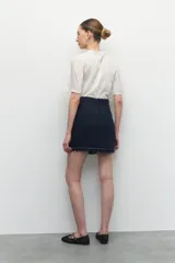 Minifalda de tweed color blanco con flecos en el ruedo.