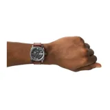 Reloj Fossil Neutra para hombre, con caja de acero color gris plomo de 42mm y correa de cuero marrón de 22mm. Esfera gris texturizada con efecto sunray, cristal mineral y movimiento de cuarzo de tres agujas con fecha. Resistente al agua hasta 5 ATM.
