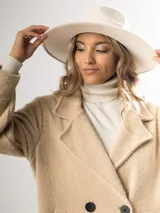 Tapado clásico color beige, con solapas de muesca, doble botonadura y bolsillos laterales.