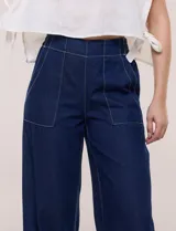 Jean de tiro alto y pierna amplia de corte wide leg, confeccionado en denim azul. Presenta cintura plana en el frente y elastizada en la espalda, bolsillos delanteros aplicados estilo parche y pespuntes a contrapunto.