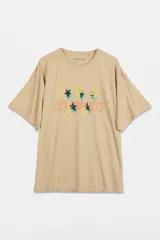 Remera de corte oversize y cuello redondo, color beige, con estampado frontal que incluye estrellas y el texto 'Les Enfants'.