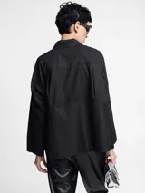 Camisa negra de algodón con botones en la parte delantera y cortes geométricos.