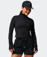 Campera deportiva Fabletics modelo Perfect Storm Cropped de color negro, con cierre frontal completo, cuello alto, bolsillos laterales y mangas largas con aberturas para los pulgares.