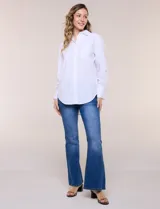 Camisa blanca de corte holgado, marca Magaschoni, con cuello camisero, mangas largas con puños anchos, bolsillo en el pecho y ruedo curvo.