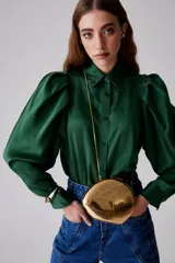 Camisa verde esmeralda de seda con cuello clásico, mangas largas abullonadas y cierre frontal con botones.