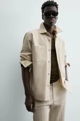 Sobrecamisa de algodón color beige claro, de corte relajado, con cuello solapa, manga larga y dos bolsillos de plastrón en el pecho.