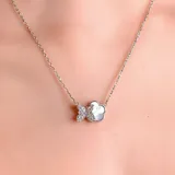 Collar de cadena fina plateada con un dije en forma de mariposa, donde una mitad está decorada con cristales brillantes y la otra mitad presenta un acabado liso y nacarado.