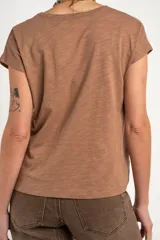 Remera de algodón flame color blanco marfil, con cuello redondo amplio y mangas cortas holgadas.