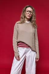 Sweater de tejido de punto negro con tramas de ochos en las mangas y laterales, cuello redondo a la base y mangas largas.