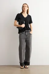 Remera negra de manga corta con escote en V y sutil detalle de lurex brillante en el cuello y las mangas.