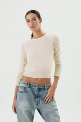Sweater color crudo de lana, entallado y con diseño de hombreras.