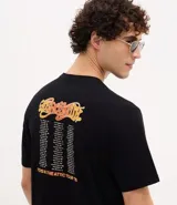 Remera negra de algodón con estampado localizado de la banda Aerosmith en tonos naranja y amarillo. Presenta cuello redondo y manga corta.