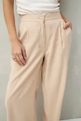 Pantalón sastrero ancho color crema con finas rayas verticales, de cintura alta con pinzas.